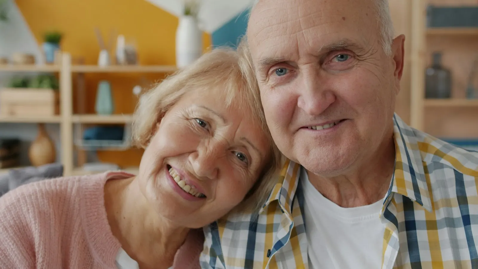 Smiling older couple sitting close together at home
