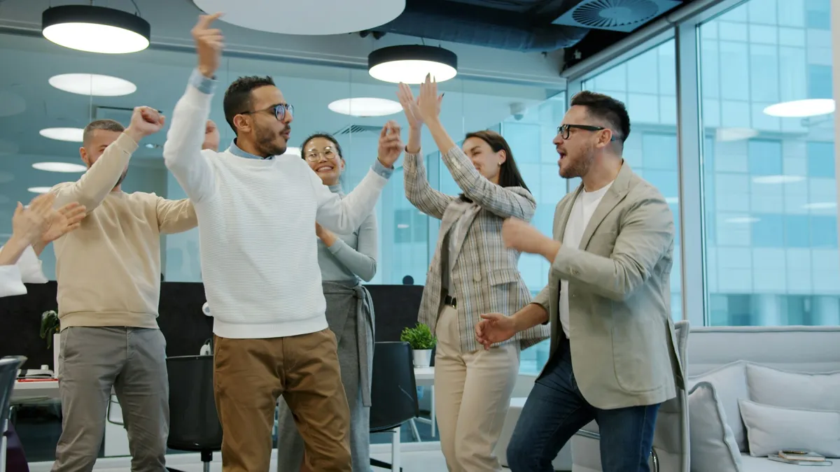 Diverse team celebrating a success together in the office